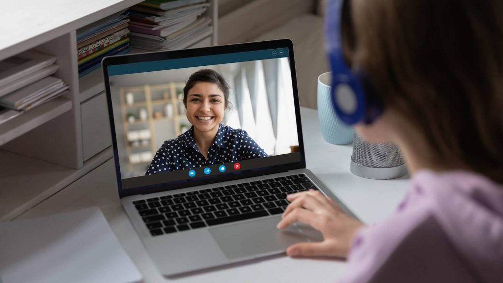 Where to Hire Virtual Assistant - A person's hands on a laptop, engaged in a video call with a smiling woman, suggesting the search for and employment of a remote virtual assistant